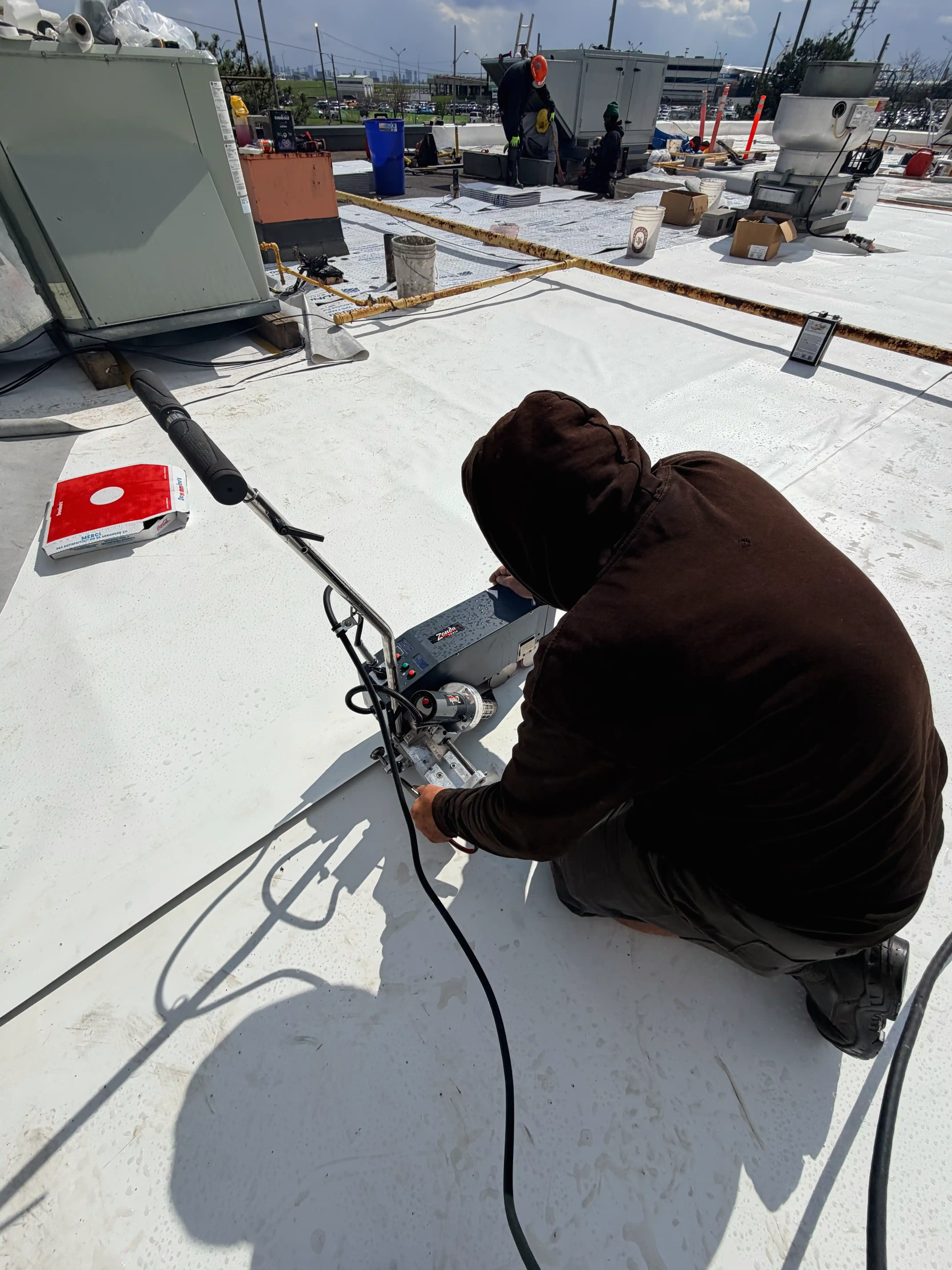 Technician adjusting Zonda welder on roof